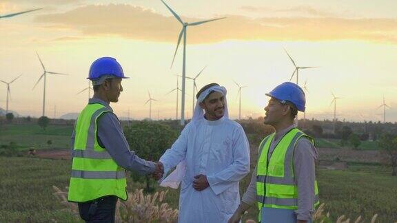 中东阿拉伯商人工程师技术人员做握手和维护风力涡轮机农场