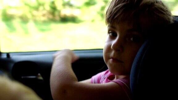 一个小女孩坐在汽车安全座椅上的肖像