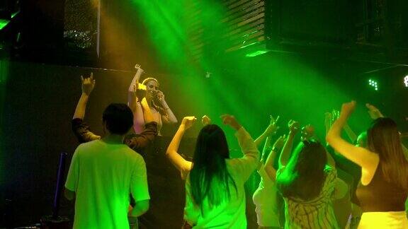 女DJ在灯光效果的音乐会晚会上跳舞年轻人在俱乐部跳舞夜生活派对和迪斯科概念与灯光效果