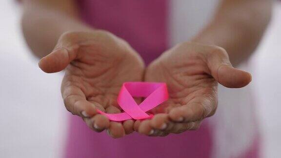 患者手持一条丝带象征着乳腺癌患者