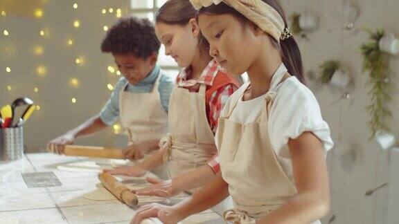 亚洲女孩擀面团的孩子烹饪班