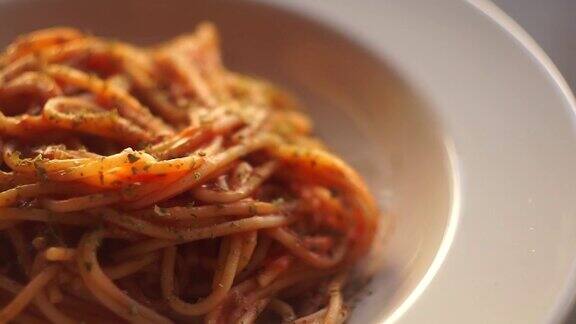 番茄酱意大利面带有番茄酱的意大利细面条在厨房背景的白色盘子上旋转意大利菜