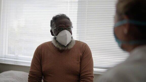 病人戴着防护口罩与医生交谈