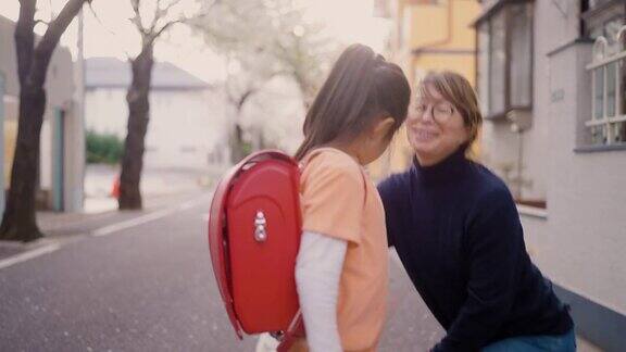 母亲送她小学的小女儿去上学