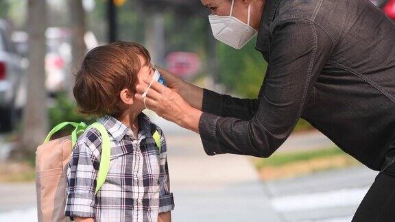 白人母亲给儿子戴上防护面罩然后送他去学校