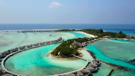 鸟瞰图的热带岛屿度假酒店与白色的沙棕榈树和绿松石印度洋上的马尔代夫