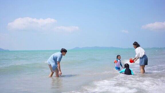 一个亚洲家庭暑假在海滩上玩水