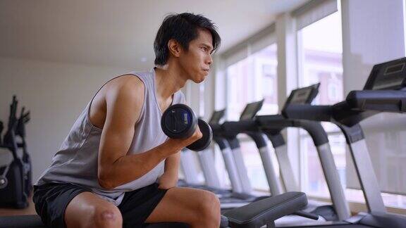 亚洲年轻的没有手臂的截肢者在健身房里举起重量哑铃有吸引力的快乐残疾运动员在体育场内进行运动和锻炼以保持肌肉的健康和健康