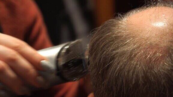 理发师用电动理发器为男士理发