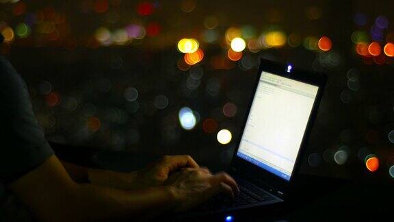 一名男子在屋顶上使用笔记本电脑背景是淡淡的散景
