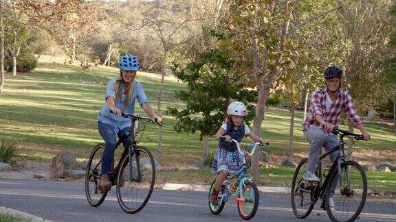 在一个公园里一家人一起骑自行车