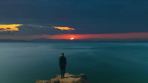 男子站在山顶上看落日