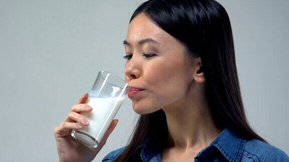 美丽的亚洲女人喝一杯牛奶健康饮食必需营养