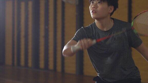 亚洲华人羽毛球运动员在羽毛球场上进行比赛