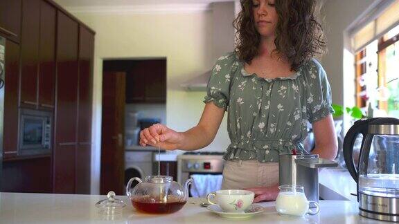 一个女人用干茶叶给自己泡茶