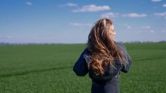 穿过田野的女孩自由的女孩在绿色的田野上奔跑