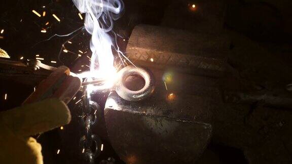 特写男子焊接金属与火花灯在晚上