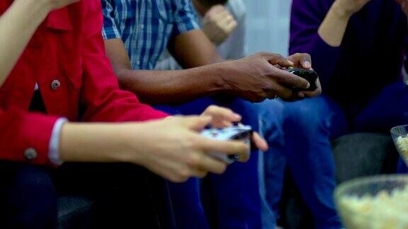 手持游戏操纵杆并按下按钮人们就可以玩游戏控制台朋友们在家里玩游戏机特写镜头
