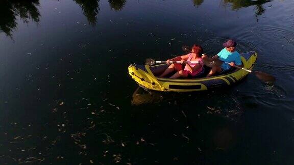图片:一对成年夫妇在夏天的傍晚在河上划皮艇