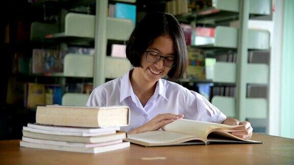 亚洲女学生在公共图书馆看书