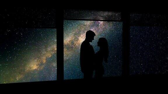 一个男人和一个女人站在窗前星空背景时间流逝