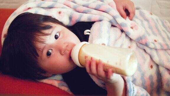 亚洲女婴用奶瓶喝牛奶