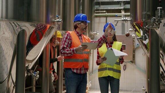 在啤酒厂的生产过程中一组员工在检查啤酒罐