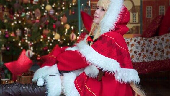 可爱的女孩cosplay圣诞Miku圣诞老人服装和礼物新年的精灵坐在地板上