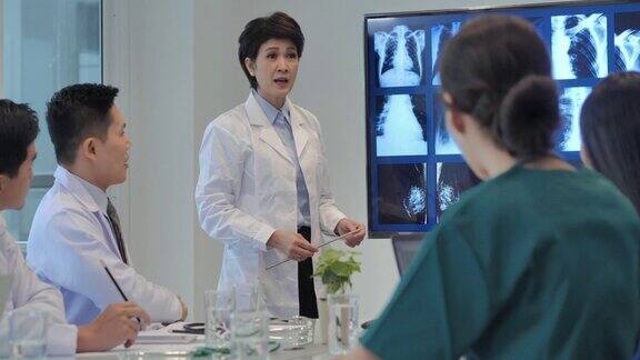 自信的亚洲女医生在医院的会议室向医务人员做报告