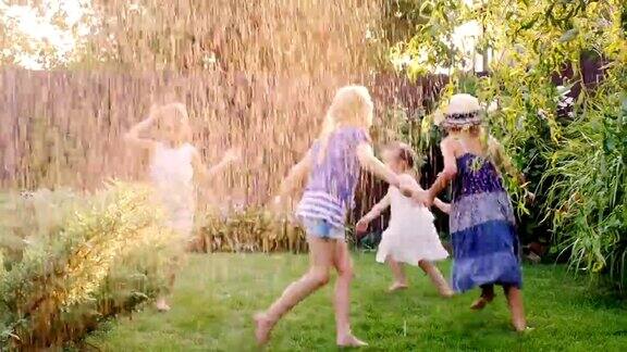 一群无忧无虑快乐的孩子在花园里玩耍光着脚在草地上奔跑任凭水流或雨水冲刷