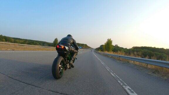 日落时分男人骑着摩托车在高速公路上飞驰