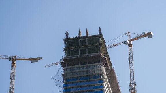 建筑工地上的塔式起重机在高层建筑中吊装重物间隔拍摄