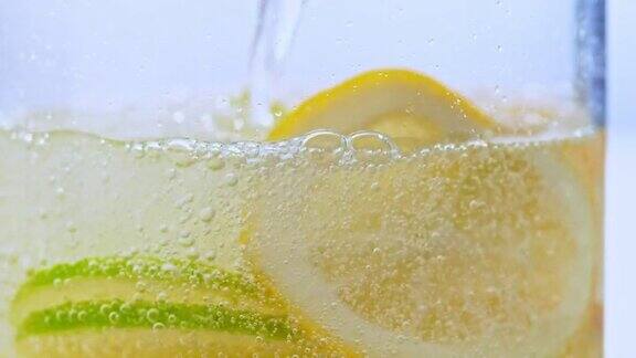 将苏打水倒入装有柠檬和酸橙片的玻璃杯中