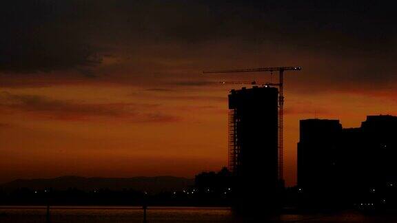 建筑和建筑起重机剪影在日落的城市风景伊兹密尔城市土耳其-4K超高清