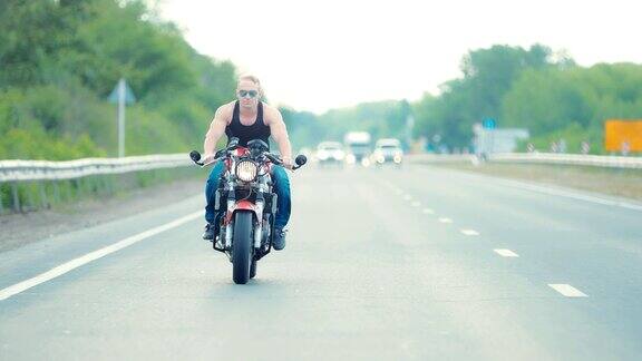 年轻男子骑摩托车在高速公路上戴着墨镜