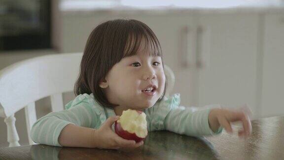 小女孩在家厨房吃苹果
