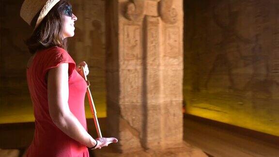 一个年轻的女人正在参观阿布辛贝神庙的内部装饰和珍贵的象形文字在埃及南部的努比亚靠近纳赛尔湖拉美西斯二世法老庙4k视频