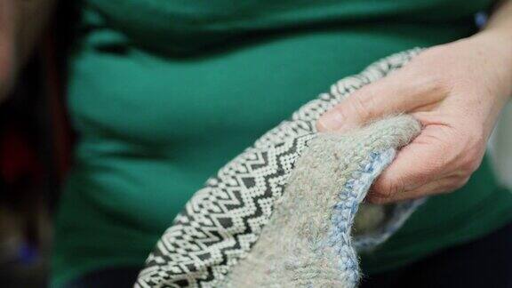 女人用线和针缝纫缝纫面料来编织袜子