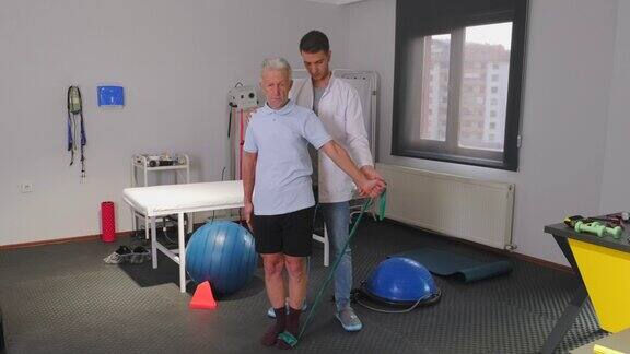 康复理疗师用胶布帮助老年人锻炼