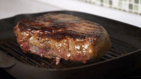 在网格上烤牛排的特写多汁的肉排烹饪在烧烤上