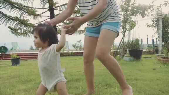 亚洲母亲帮助她的女儿学习走路