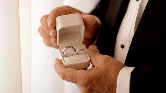 老人打开装有结婚戒指的白色盒子