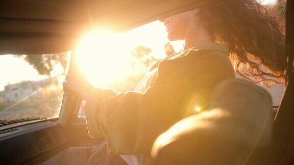 日落时分一位年轻女子探出车窗