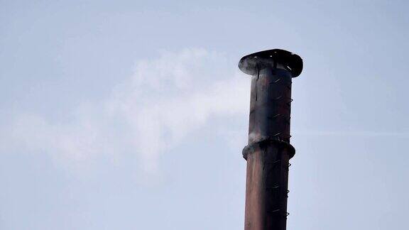 烟从房子的烟囱里冒出来屋顶上的管子烟囱中国的房子有烟囱的房子蓝天中烟雾缭绕烟囱和天空的云