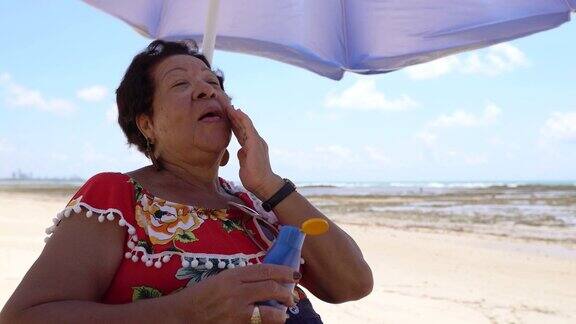 在海滩上用防晒油的女人