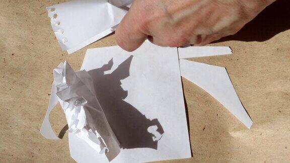 4k视频一个女人的手在棕色牛皮纸的背景下揉皱白纸特写镜头