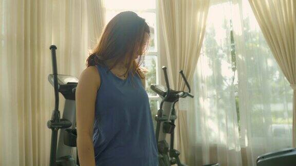 年轻的亚洲妇女在运动服装伸展身体之前在健身房锻炼