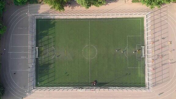 当地的孩子们在学校体育场的操场上踢足球鸟瞰图