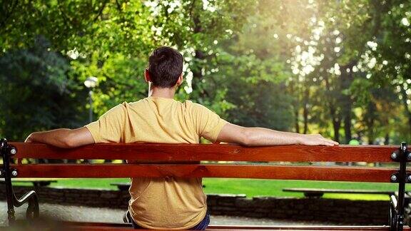 年轻人坐在公园的长椅上