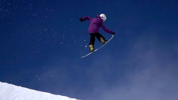 慢动作:职业滑雪板运动员在半空跳跃